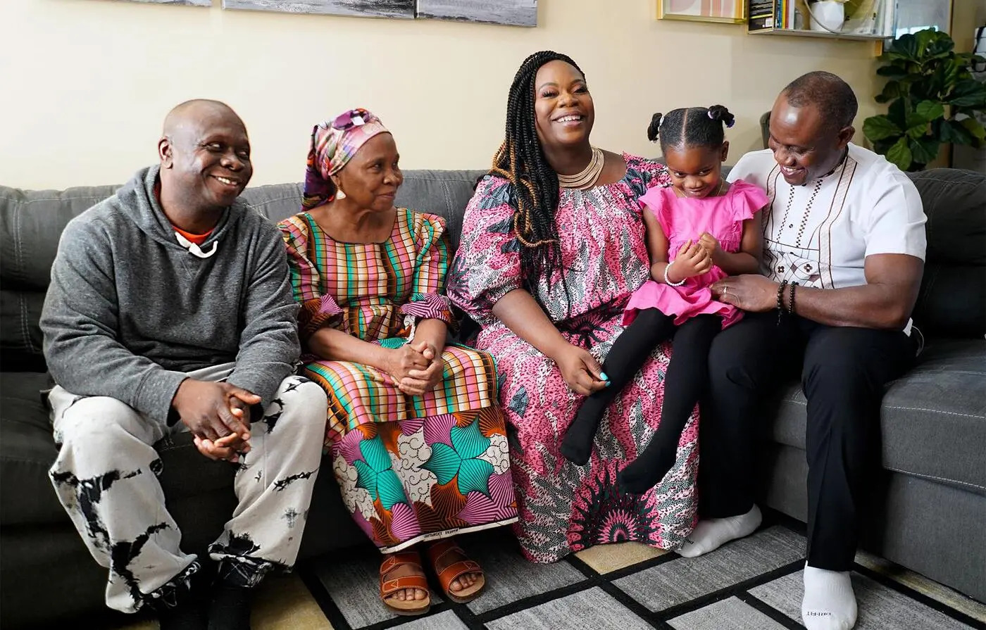 Una familia afrodescendiente refugiada sentada en un sillón