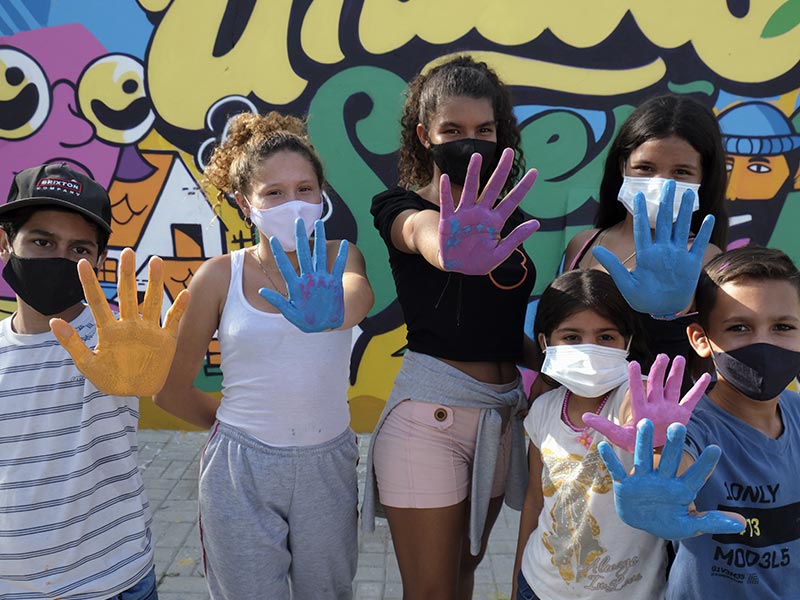 Niñas, niños y jóvenes del Centro de Integración Local La Milagrosa en Colombia pintan sus sueños y esperanzas para el futuro en el mural Soñando Juntos.