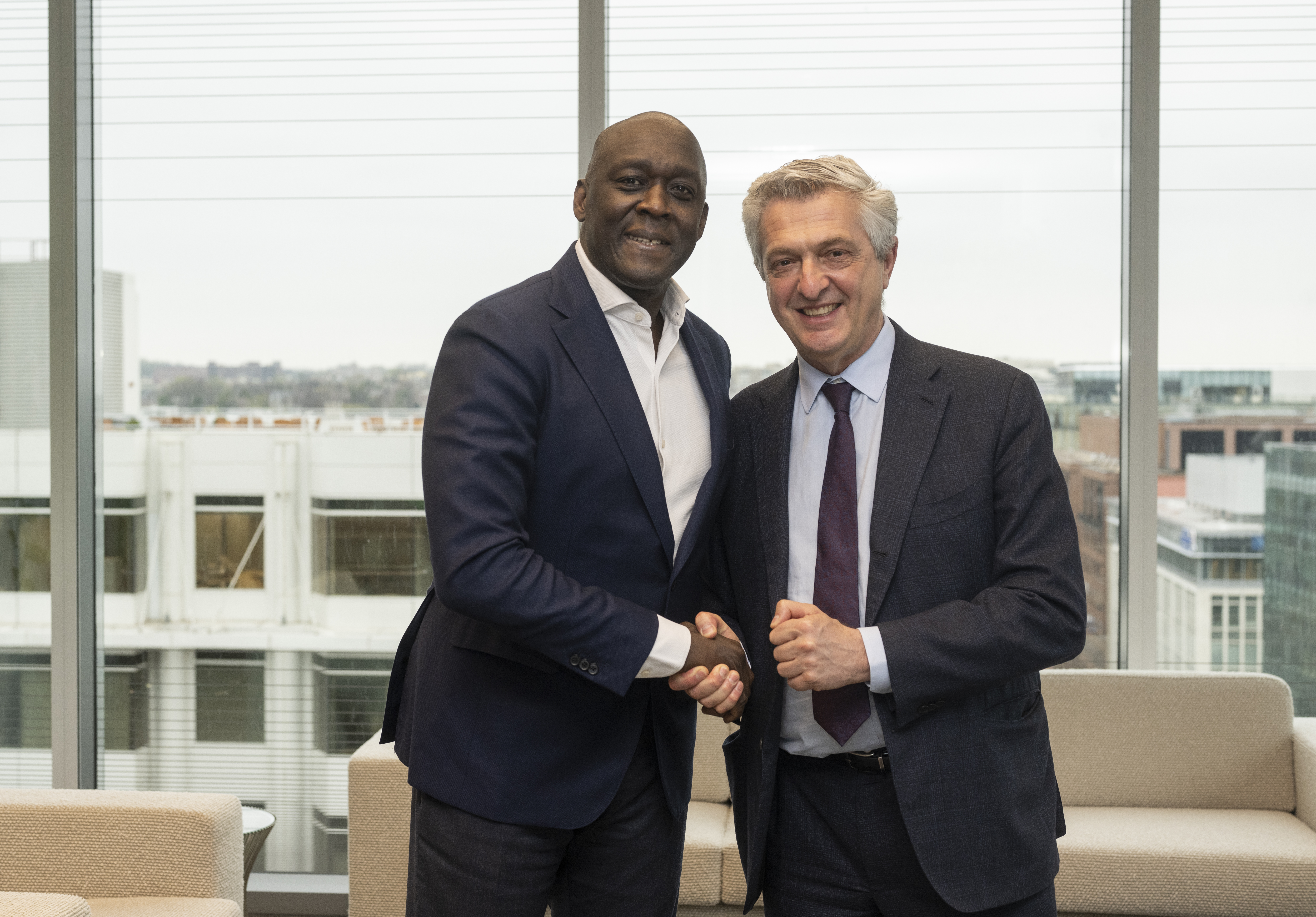 Two men shaking hands and posing for the camera