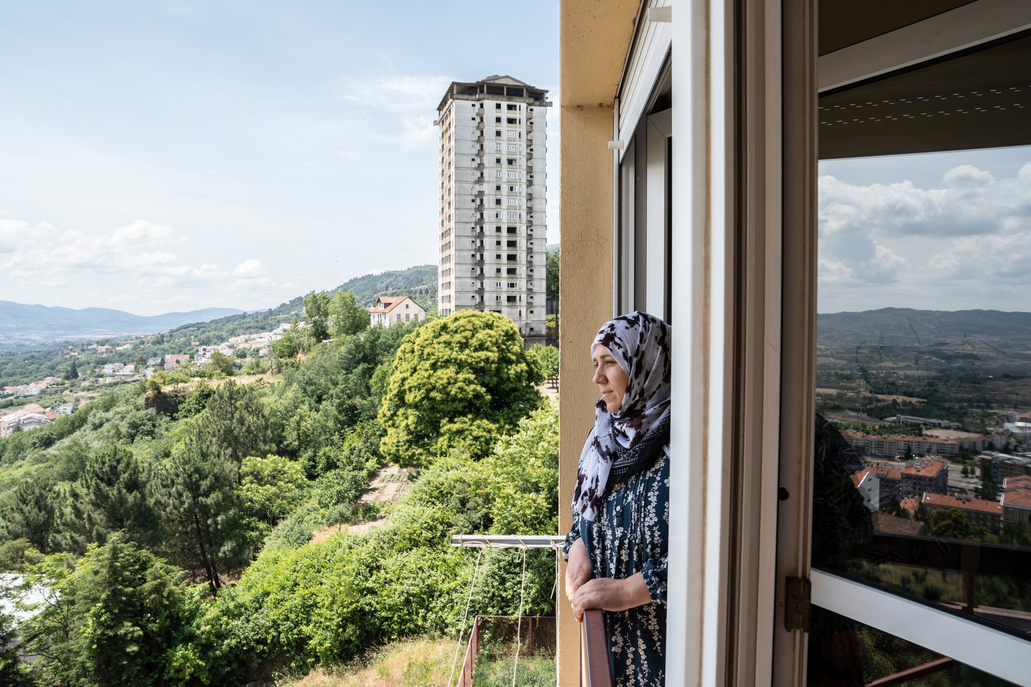 Una mujer mira por la ventana de un rascacielos