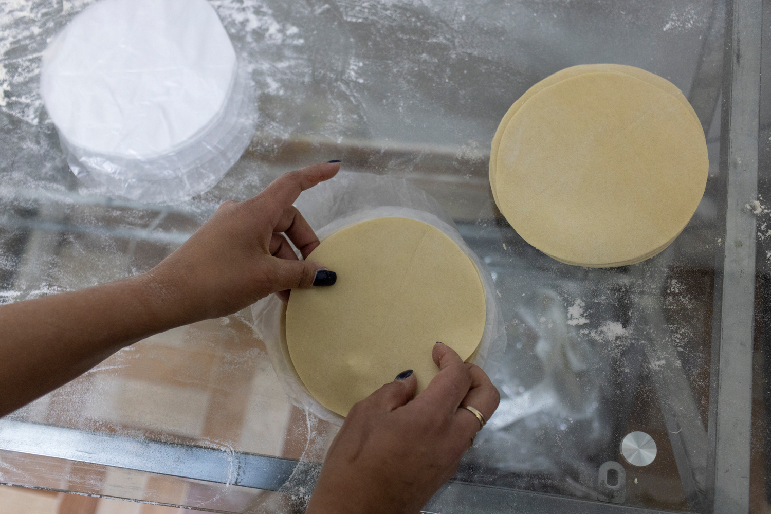 Un par de manos empaqueta masa en forma de tortilla