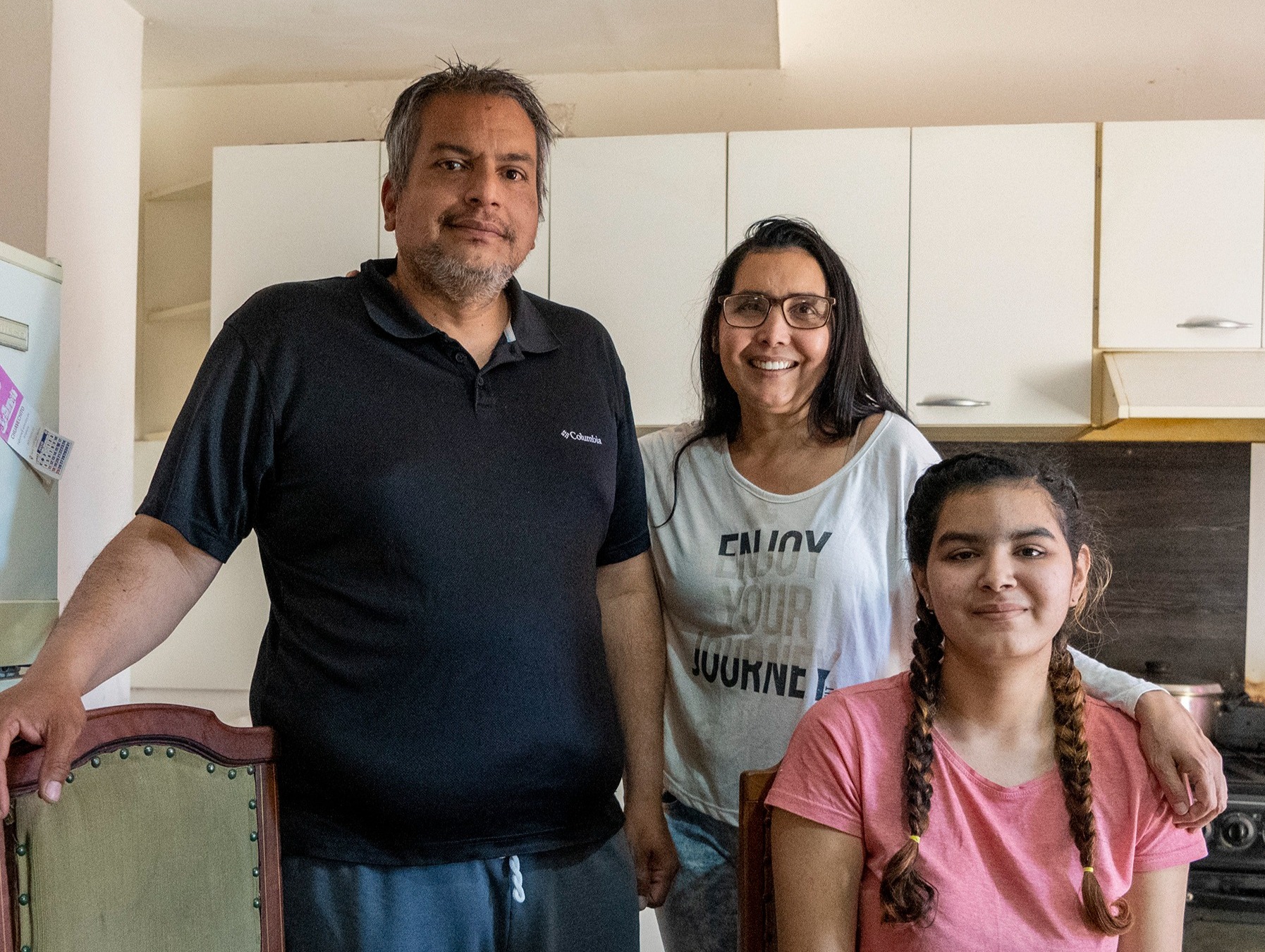 Un hombre, una mujer y una niña sonríen para la foto