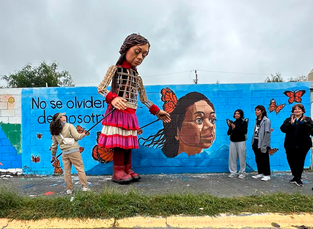 La pequeña Amal frente al mural realizado en su honor, que la retrata rodeada de mariposas..