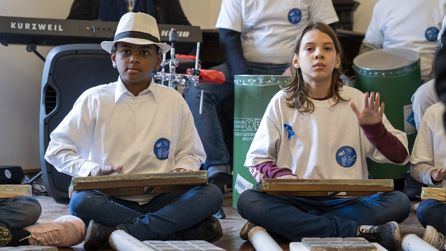 Niños tocando instrumentos de percusiones.