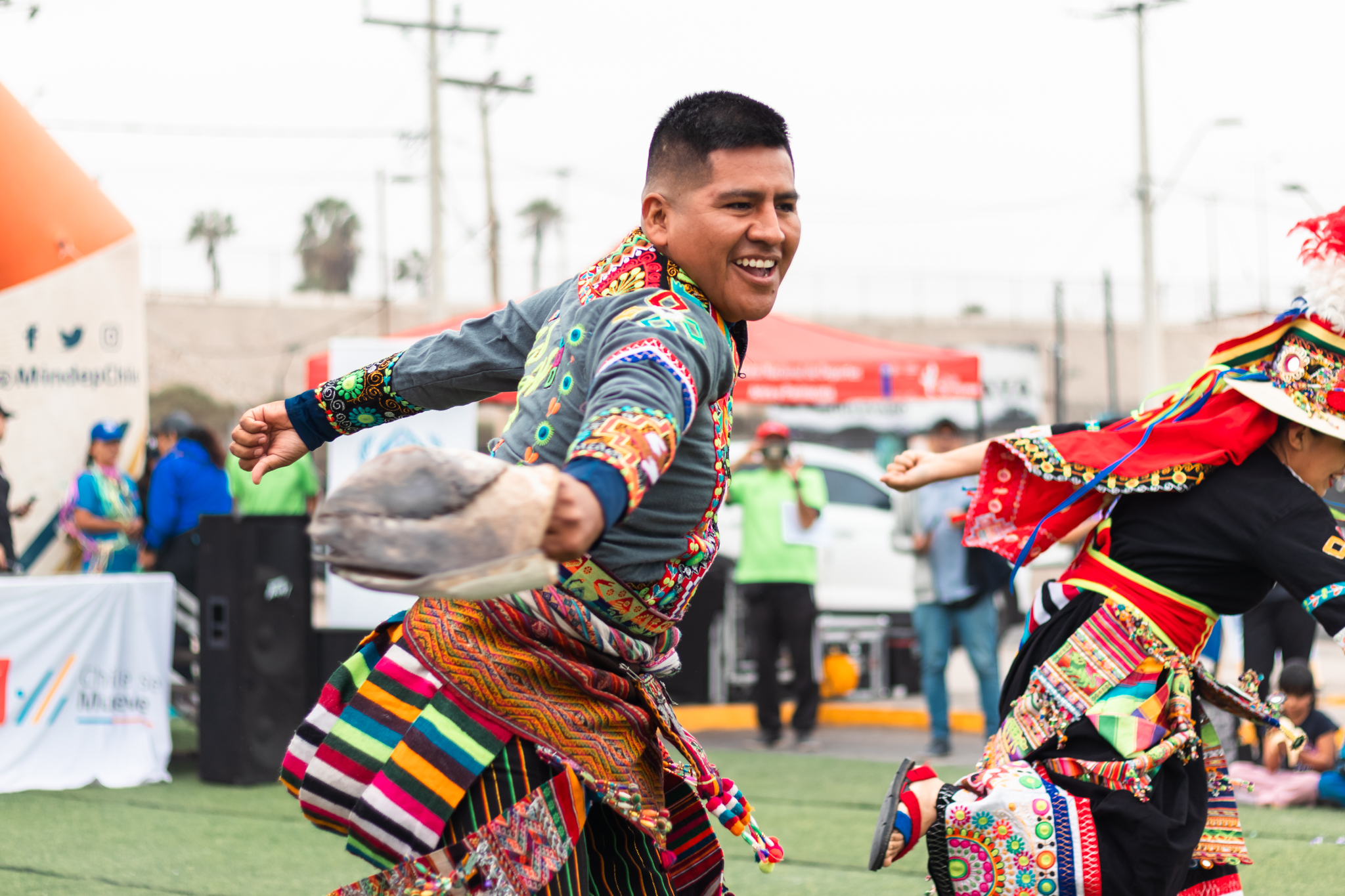 Un hombre sonríe mientras participa en una danza tradicional