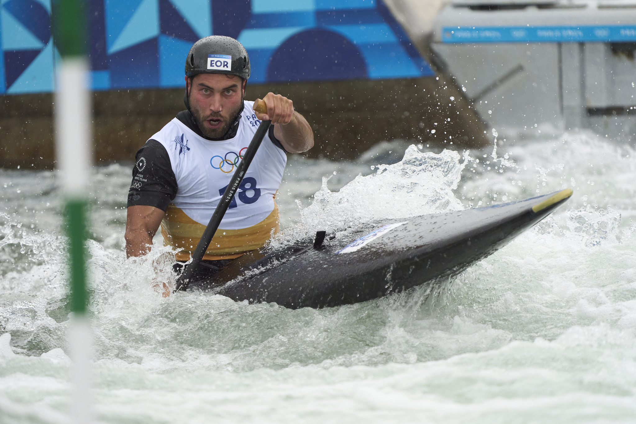 Un kayakista durante una competencia olímpica en aguas revueltas.