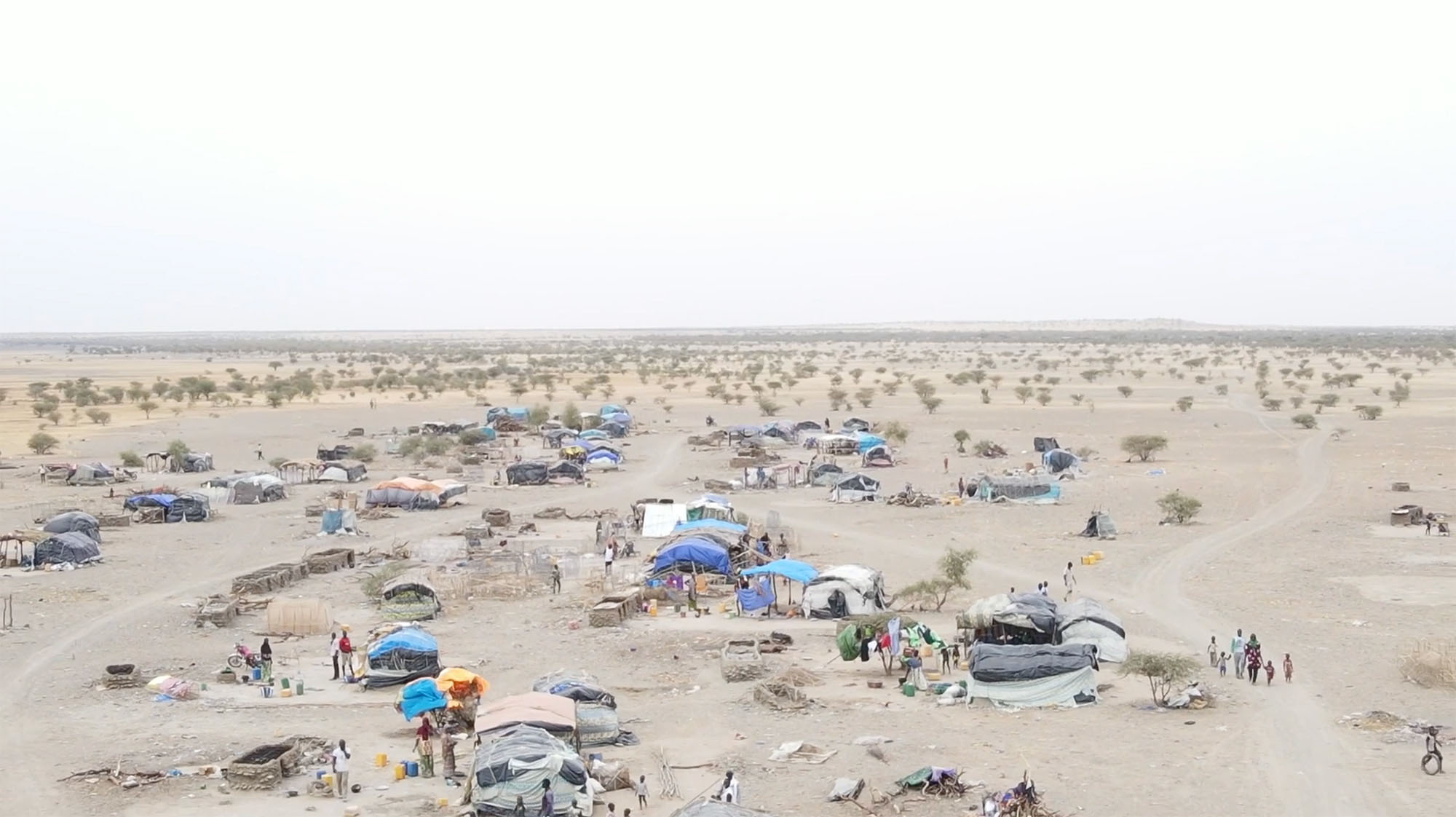 Carpas construidas con lonas y otros materiales en medio de una zona desértica