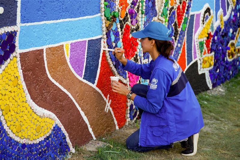 La Embajadora de Buena Voluntad de ACNUR María Daniela Velasco da los toques finales al mural.