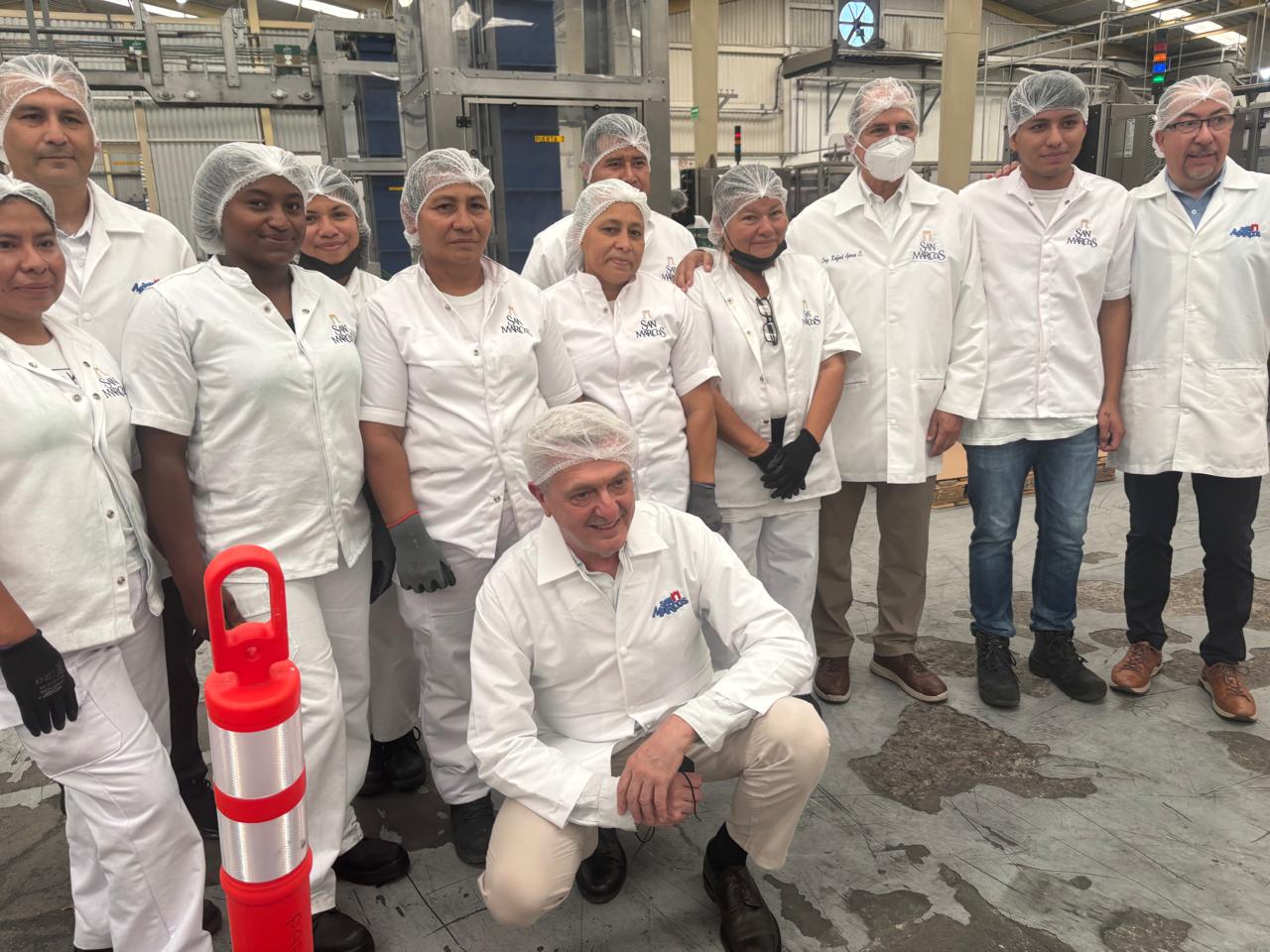 Foto de grupo del Alto Comisionado con trabajadores y trabajadores de la planta lechera.