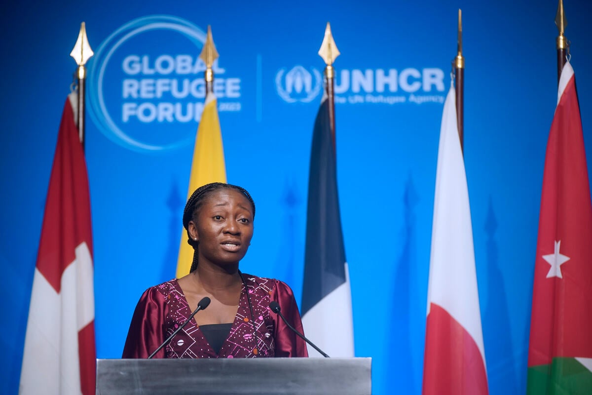 Una mujer togolesa habla desde un podio; detrás suyo, cinco banderas.