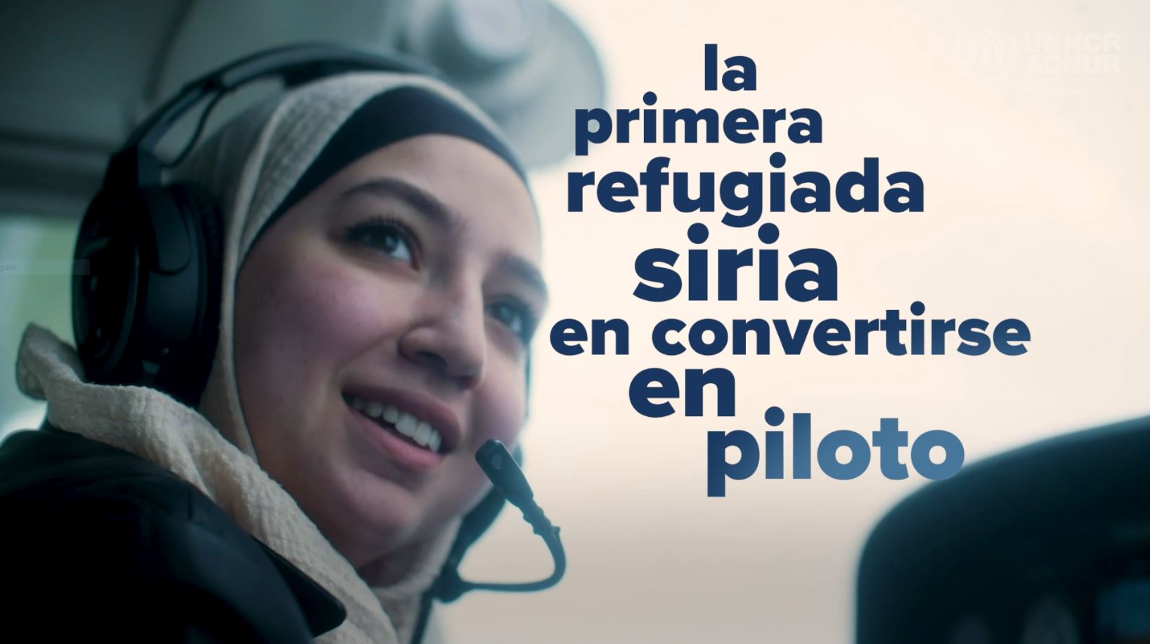 Una joven siria, que lleva puesto un hiyab, sonríe dentro de la cabina de un avión