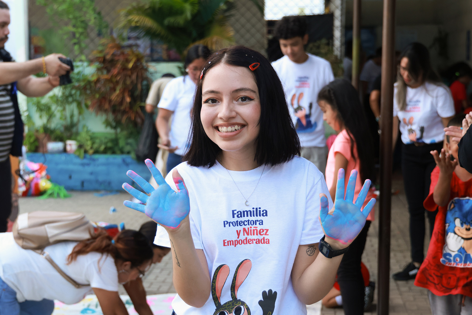 Una joven muestra sus manos con pintura azul luego de una actividad lúdica.