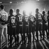 Imagen generada por IA de un equipo de fútbol alineado en el campo dentro de un estadio muy iluminado