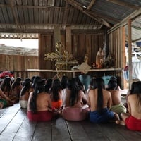 Mujeres Wounaan de espaldas frente a imágenes religiosas