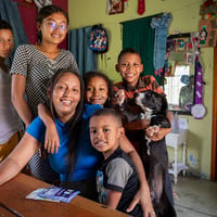 Una mujer con sus cinco hijos alrededor de una mesa en su casa