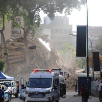 Equipos de búsqueda y rescate trabajan entre los escombros de un edificio derrumbado.