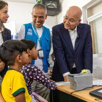 El Alto Comisionado de la ONU para los Refugiados, Barham Salih, y funcionarios de ACNUR hablan con una familia de Venezuela en un centro de protección de Lima, Perú.