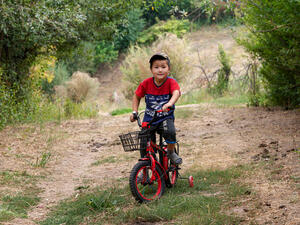 Un joven con camiseta roja pasea en bicicleta