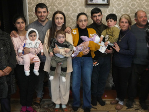 Una familia posa para una foto de grupo en la sala de su casa.