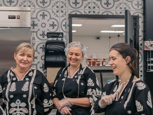 Tres mujeres ucranianas ríen entre sí; dos de ellas llevan puesto un gorro de malla 