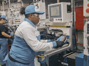 Una obrera trabajando con maquinaria en una fábrica.