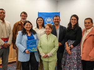 Un grupo de tres hombres y 5 mujeres sonríen para la foto