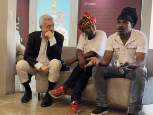 Tres personas sentadas hablando durante un evento público.