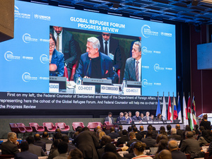 Un hombre habla en una pantalla gigante ante el público que asiste a la sala de conferencias