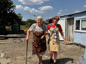 Mujer ucraniana mayor caminando con una facilitadora social