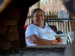 Una mujer mira hacia la cámara sonriendo.
