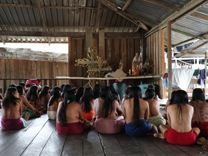 Mujeres Wounaan de espaldas frente a imágenes religiosas