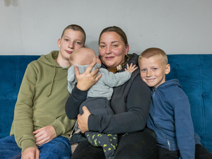 Una madre y sus tres hijos sentados en un sofá