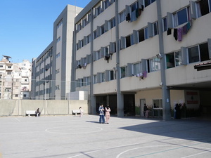 Vista de un patio en un edificio escolar con ropa tendida en cuerdas que salen por las ventanas