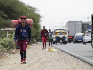 Ángelo, venezolano de 22 años, camina por la carretera Panamericana hacia Tumbes, en Perú, en diciembre de 2021.