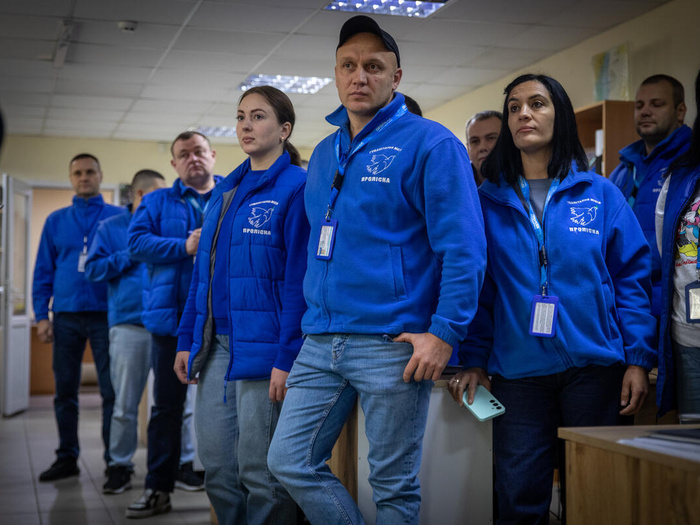 Un grupo de personas de chaqueta azul posa para la cámara.
