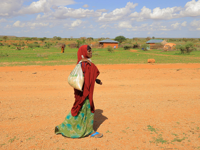 Etiopía. Ilama Ahmed, de 31 años, desplazada interna, camina hacia su casa con los alimentos que compró al propietario de una tienda, Ahmed Salah Ahmed, en el campamento de desplazados internos de Darso.