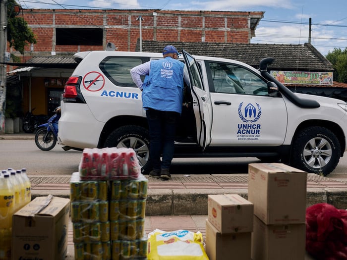 Un trabajador de ACNUR se asoma a la parte trasera de un vehículo blanco con el logotipo de ACNUR