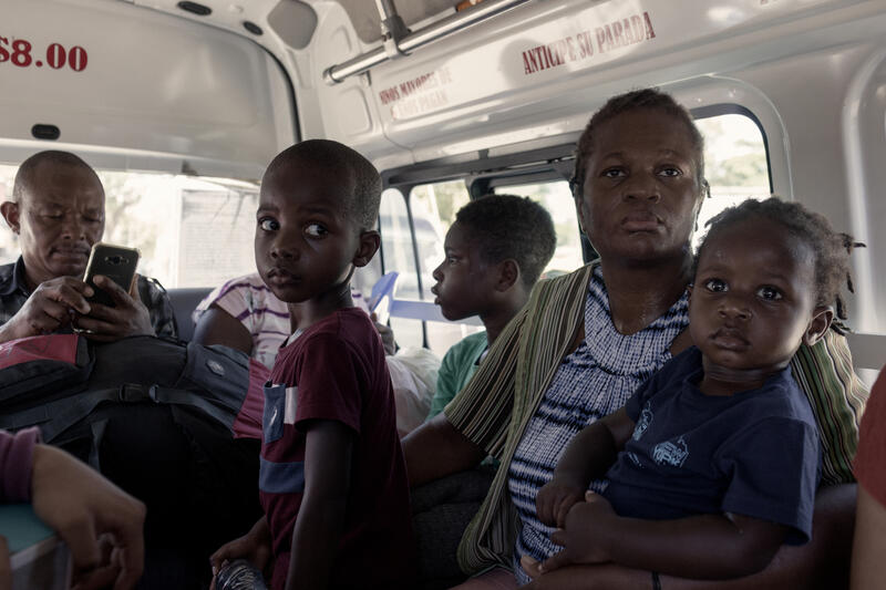 Una familia viaja sentada en un minibús.