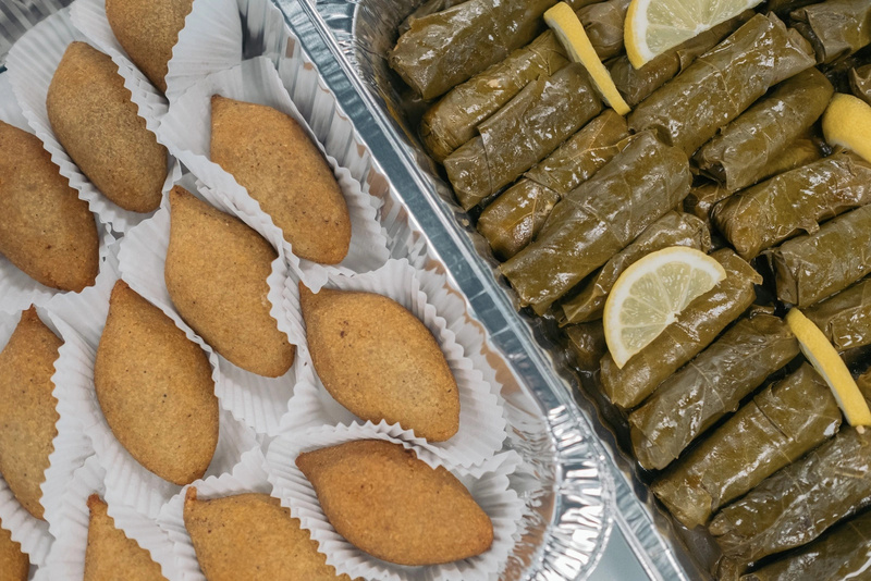 A la izquierda, una serie de croquetas rellenas que se conocen como kibbeh; a la derecha, un aperitivo sirio que se prepara con hojas de parra rellenas de arroz y varias verduras, que se sirve frío y se conoce como yalanji