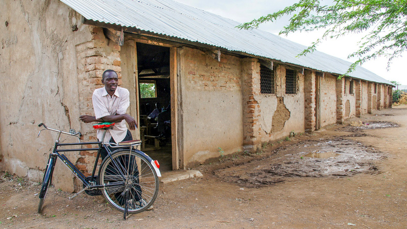 Un hombre se apoya en su bicicleta cerca de la entrada de una iglesia local en el campamento de refugiados de Kakuma, Kenia