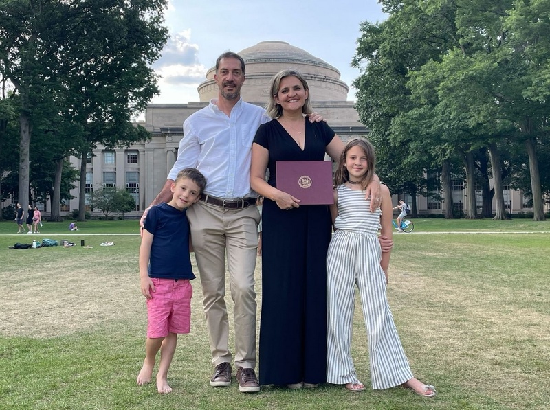 Una familia compuesta de padre, madre, un niño y una niña posa para la cámara sonriendo.