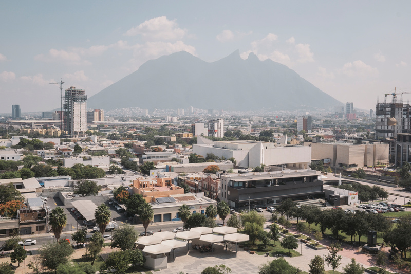 Un cerro domina el horizonte lleno de neblina del paisaje urbano moderno