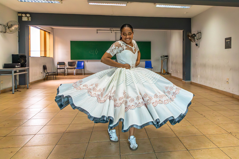 Una joven bailarina danza con su vestido dentro de un aula