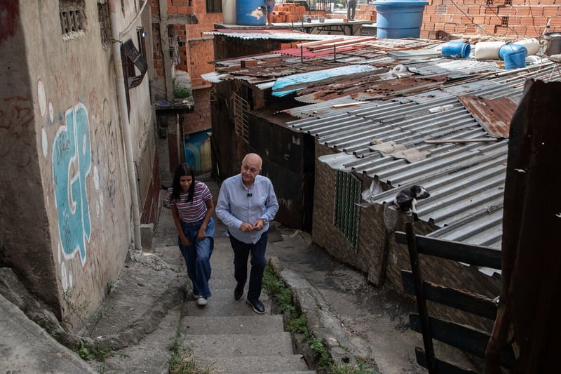 Andriuska caminando junto al Alto Comisionado Narham Salih en un callejón de su barrio.