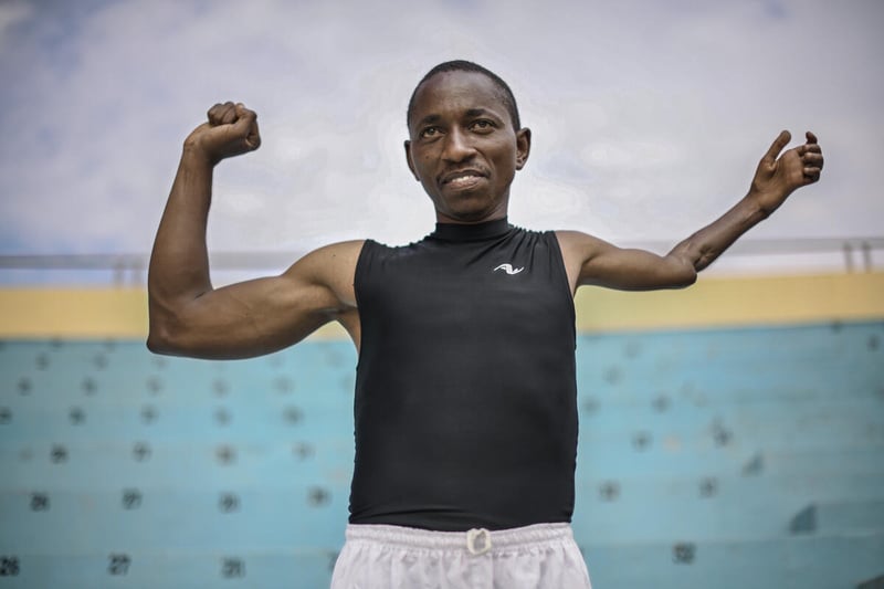 Un hombre que vive con una discapacidad por una grave lesión que sufrió en el brazo izquierdo se ejercita en un campamento de refugiados