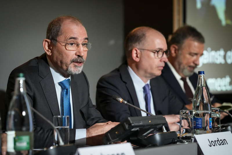 Tres hombres hablan en un panel