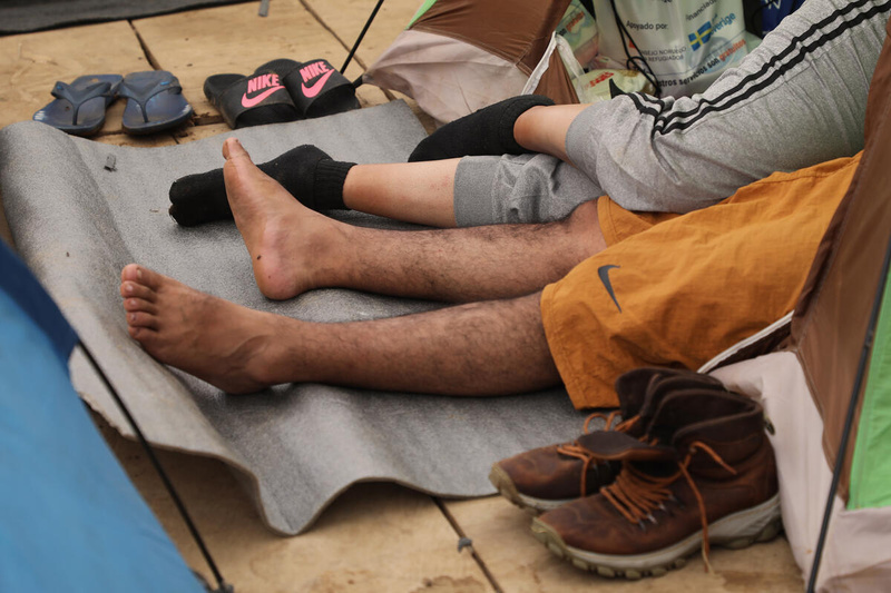 dos personas descansan sobre una colchoneta de acampar. Solo sus piernas se ven en la foto.