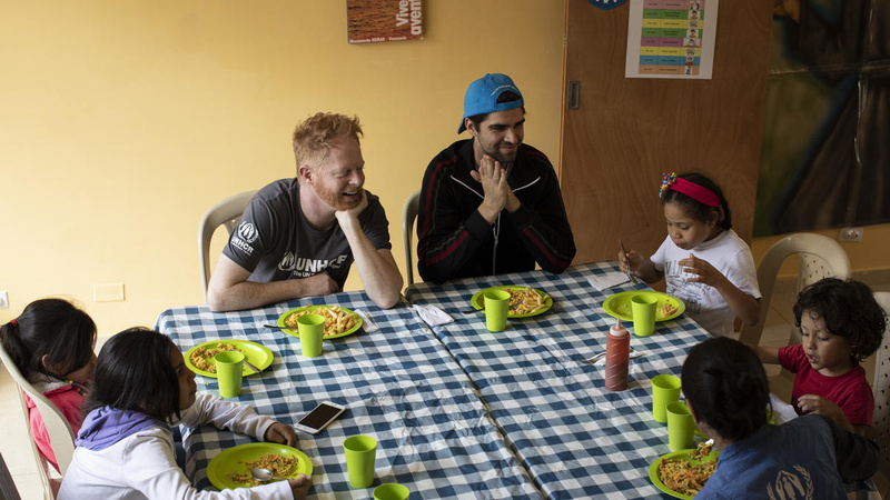Colombia. UNHCR supporter Jesse Tyler Ferguson (centre) and his husband Justin Mikita (centre-right) spend time with Venezuelan refugee and migrant children