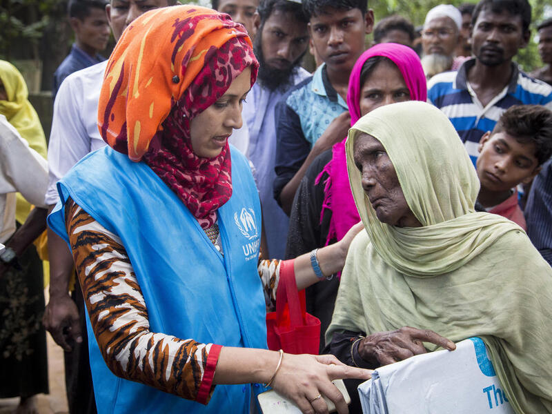 Una mujer mayor recibe una lona de plástico de una trabajadora de ACNUR en el campamento de refugiados de Kutupalong, en Bangladesh.