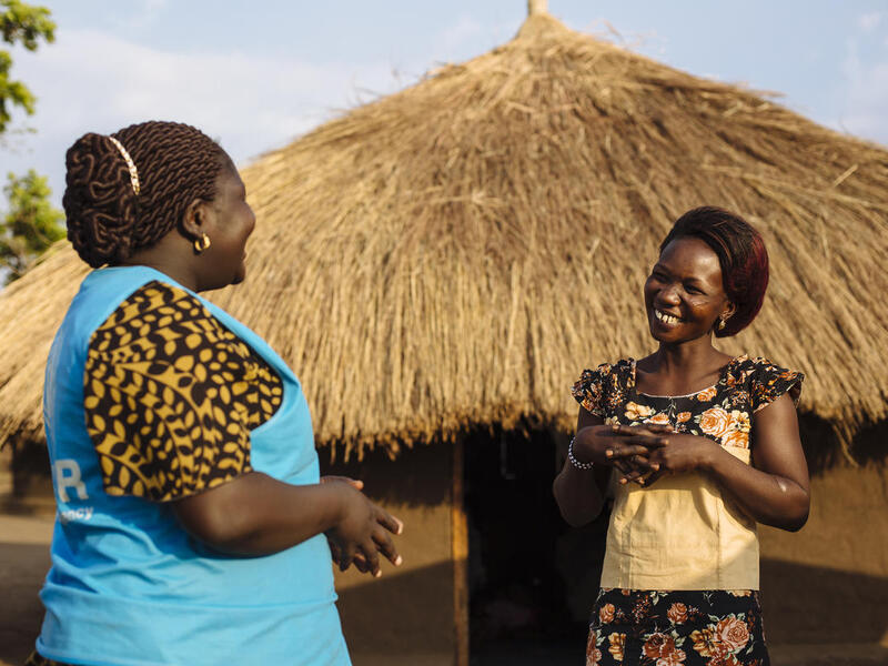Dos mujeres africanas conversan; una de ellas (la que está a la izquierda) trabaja en ACNUR.